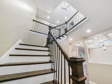 Staircase with dark wooden steps and black iron railing