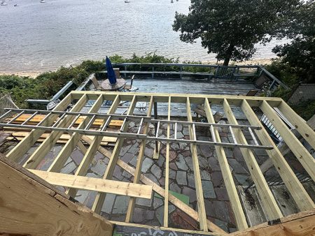 Deck framing under construction with view of the water