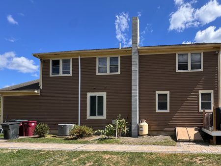 Side view of a house with a chimney and yard
