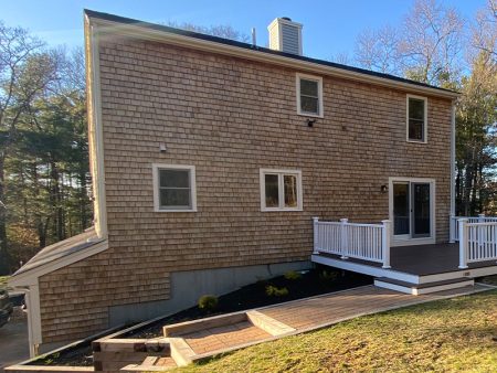 A house with a deck and steps leading to the backyard.