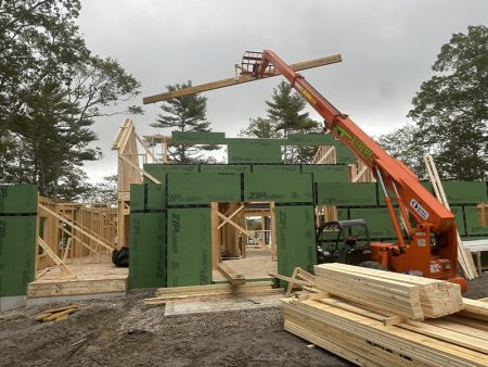 Crane lifting wooden beams on construction site