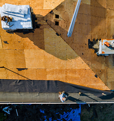 Aerial view of construction workers installing roofing materials.